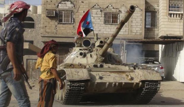 Fighters loyal to Yemen's President Abd Rabbuh Mansur Hadi stand by a tank they used in fighting against Houthi fighters in the southern port city of Aden, Yemen, on April 11, 2015. (Reuters/Stringer)
