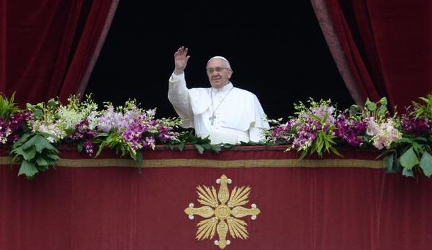 Pope Francis greets the crowd from the central loggia of St Peters' basilica after the "Urbi et Orbi" blessing for Rome and the world following the Easter Mass, on April 5, 2015, in Vatican City. (AFP Photo/ Filippo Monteforte)
