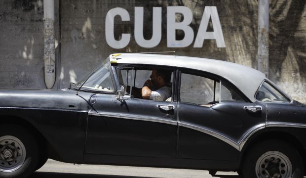 A man drives his taxi past a Cultural Center in Havana, Cuba, on April 14, 2015. (AP Photo/Desmond Boylan)