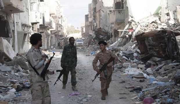 Members of Libyan pro-government forces, backed by the locals, walk with weapons during clashes in the streets with Shura Council of Benghazi Revolutionaries, an alliance of former anti-Gaddafi rebels who have joined forces with Islamist extremist groups, in Benghazi, Libya, on April 1, 2015. (Reuters/Stringer)
