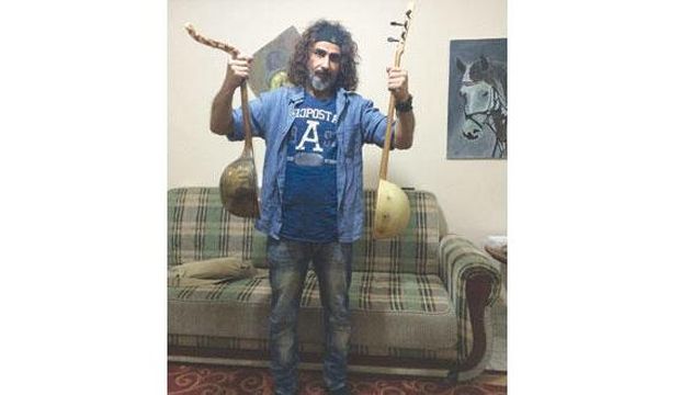 Iraqi artist Wissam Al-Farati holds his lutes, named "Tigris" and "Euphrates," which he fashioned out of a soldier's helmet and a pickaxe used to dig battle trenches, at his home in Baghdad, Iraq. (Asharq Al-Awsat)