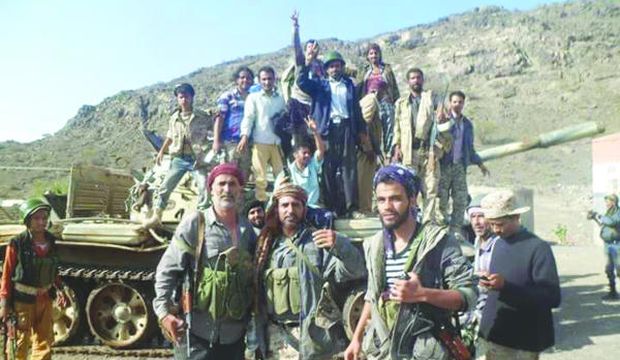 Yemeni Popular Resistance forces loyal to President Abd Rabbuh Mansur Hadi pose atop and in front of a tank after recapturing the Al-Dalea province in southern Yemen, on May 25, 2015. (Asharq Al-Awsat)