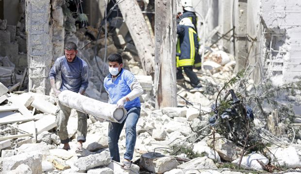 Men carry an oxygen tank from the Red Crescent medical center after it was bombed, in Al-Sakhour neighborhood of Aleppo, on April 28, 2015. (Reuters/Hamid Khatib)