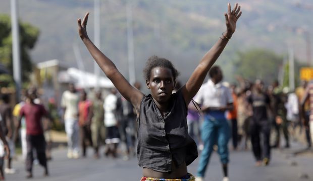 A demonstrator  raises her hands in the air as she faces soldiers in the Musaga neighborhood of Bujumbura, Burundi, on May 18, 2015. (AP Photo/Jerome Delay)