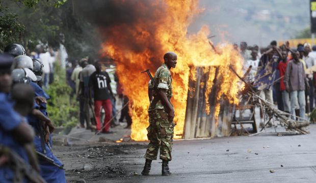 A soldier stands between demonstrators and riot police facing off in the Musaga district of  Bujumbura, Burundi, on May 4, 2015. (AP Photo/Jerome Delay)