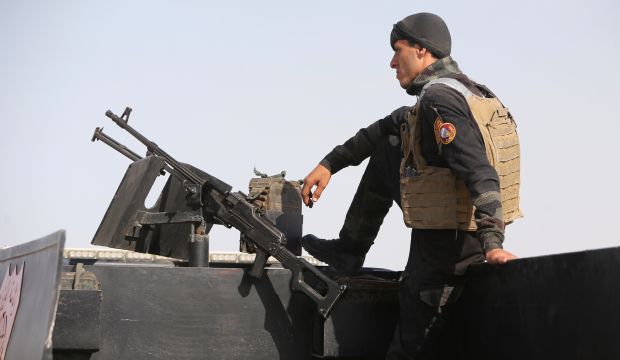 A member of the Iraqi Interior Ministry's anti-terrorism forces stands guard on a vehicle outside the Habaniyah military base, near Anbar province's capital Ramadi, on May 8, 2015. (AFP Photo/Ahmad Al-Rubaye)