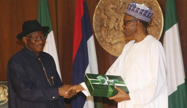 Nigeria President, Goodluck Jonathan, left, hands over a document to former General and Nigerian President elect, Muhammadu Buhari, during a ceremony ahead of the presidential inauguration at the Presidential Villa in Abuja, Nigeria, Thursday, May 28, 2015. (AP Photo)