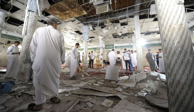 Saudi men gather around debris following a blast inside a mosque in the mainly Shi'ite coastal town of Al-Qadeeh in Saudi Arabia’s eastern Qatif governorate, on May 22, 2015.  (AFP)