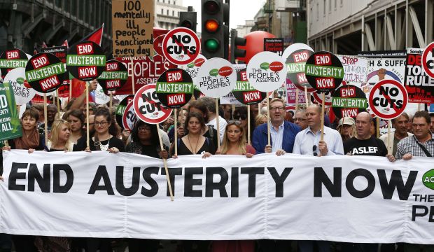 Demonstrators hold a banner as they march to protest against the British government's spending cuts and austerity measures in London on June 20, 2015. (AFP PHOTO / JUSTIN TALLIS)
