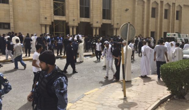 Security forces, officials and civilians gather outside of the Imam Al-Sadiq Mosque after a deadly blast struck after Friday prayers in Kuwait City, Kuwait, on June 26, 2015. (AP Photo)