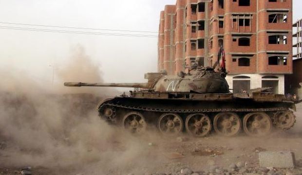 Southern militiamen loyal to Yemen's President Abd Rabbuh Mansur Hadi fire from a tank against alleged positions held by Houthi fighters in the southern port city of Aden, Yemen, on June 24, 2015. (EPA/Stringer)