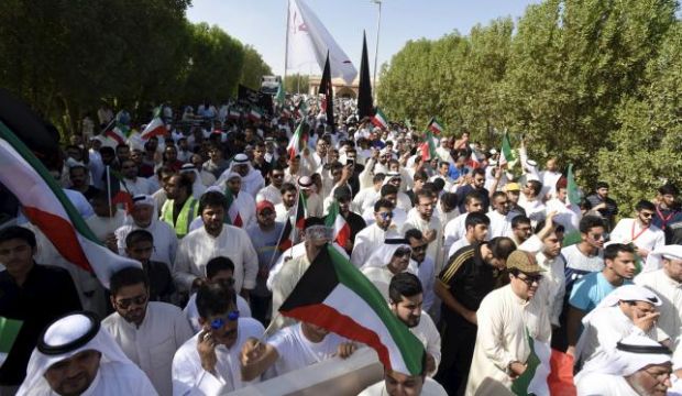 Mourners hold flags as the bodies of victims of Friday's bombing are buried in the Al-Jafariya cemetery in Suleibikhat, Kuwait, on June 27, 2015.  (Reuters/Jassim Mohammed)