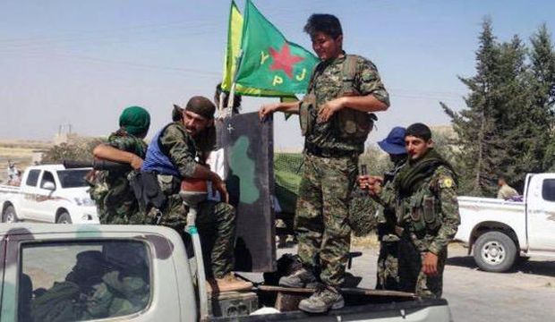 In this photo provided by the Kurdish fighters of the People's Protection Units (YPG), Kurdish fighters of the YPG sit on their pickup in the town of Ain Issa, north of Raqqa city, Syria, on June 23, 2015. (The Kurdish fighters of the People's Protection Units via AP)