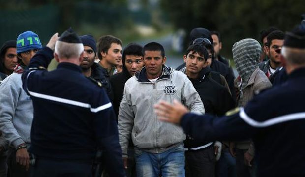 French police stop migrants on their way to catch a train to reach England, in Calais, France, on July 29, 2015. (EPA/Yoan Valat)
