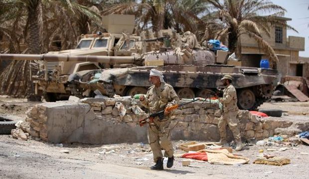 Armed Iraqi Shi’ite fighters from the Popular Mobilization units, supporting the Iraqi government forces, guard a position during clashes with the Islamic State of Iraq and Syria (ISIS) group's militants on July 15, 2015 in the town of Saqlawiya on the outskirts of Fallujah, Iraq. (AFP Photo/Ahmad Al-Rubaye)