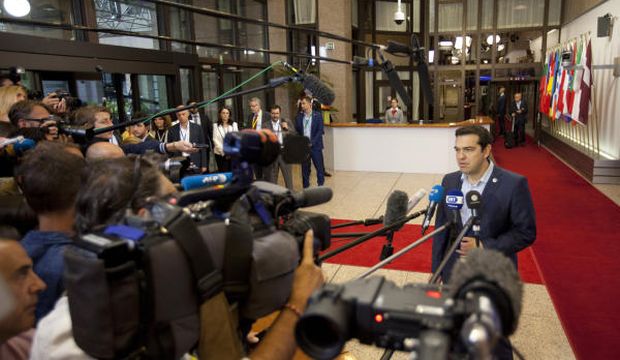 Greek Prime Minister Alexis Tsipras (R) speaks with the media as he leaves after a meeting of euro zone heads of state at the EU Council building in Brussels, on July 13, 2015. (AP Photo/Francois Walschaerts)