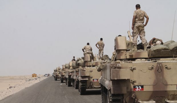 In this photo taken on Monday, Aug. 3, 2015, fighters against Shi'ite rebels known as Houthis stand on their armored vehicles on a road leading to Al-Anad base near Aden in the southern province of Lahej, Yemen. (AP Photo/Wael Qubady)