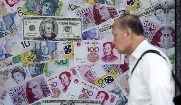 A man walks past an advertisement promoting China's yuan, US dollar and Euro exchange services at foreign exchange store in Hong Kong, China, on August 13, 2015. (REUTERS/Tyrone Siu)