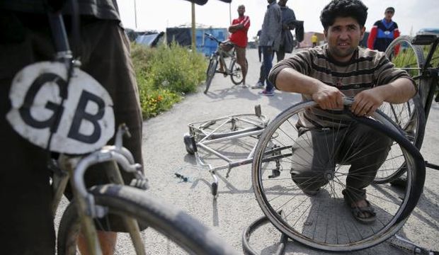 An Afghan migrant repairs his bicycle at a workshop near Calais, France, on August 1, 2015. (Reuters/Pascal Rossignol)