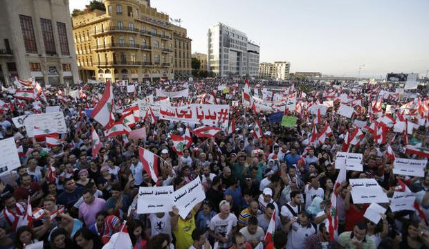 Lebanese anti-government protesters wave national flags and placards during a demonstration against the ongoing trash crisis and government corruption, in downtown Beirut, Lebanon, on August 29, 2015. (AP Photo/Hassan Ammar)