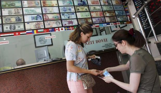 Tourists count their money after changing foreign currency to Turkish lira at a currency exchange office in Istanbul, Turkey, on August 19, 2015. (Reuters/Murad Sezer)