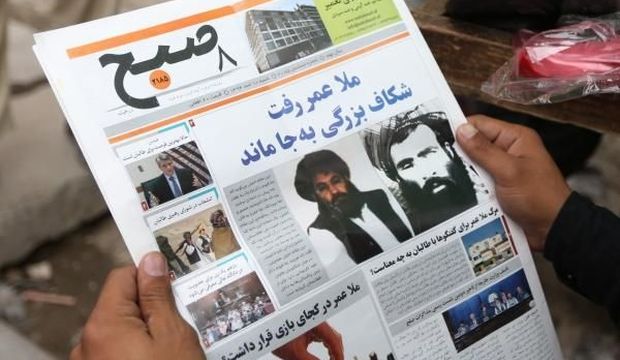 An Afghan man reads a local newspaper at a news stand carrying a headline about the new leader of the Afghan Taliban, Mullah Akhtar Mohammad Mansour, in Kabul, Afghanistan, on August 1, 2015. (AP Photo/Rahmat Gul)