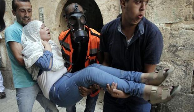 Palestinian paramedics carry a woman after Israeli security forces fired teargas and pepper spray in a street of the Muslim quarter in Jerusalem's Old City during scuffles with Israeli riot police on September 15, 2015, as Palestinians and Israeli police clashed at Jerusalem's Al-Aqsa Mosque compound for a third straight day. (AFP Photo/Ahmad Gharbali)