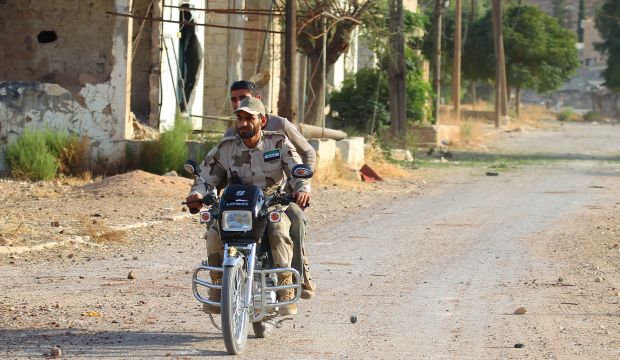 Fighters from Tajammu Al-Izza group, part of the Free Syrian Army (FSA), ride on a motorbike in Latamneh city that was hit on Wednesday by Russian airstrikes, in the northern countryside of Hama, Syria, on October 2, 2015. (REUTERS/Ammar Abdullah)