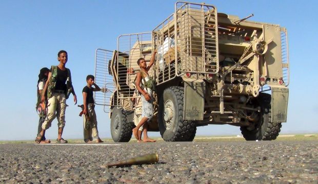 Militants loyal to Yemen's government stand next to an armored vehicle at the frontline to fight against Houthi militants in control of the Bab El-Mandeb Strait, which links the Red Sea to the Gulf of Aden, in the Yemeni governorate of Taiz, on October 3, 2015. (REUTERS/Stringer)