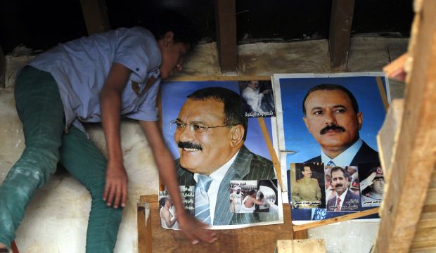 A Yemeni youth stands beside posters of the Houthi-allied former Yemeni President Ali Abdullah Saleh inside a shop in the old city of Sana'a, Yemen, on 12 October 2015. (EPA/YAHYA ARHAB)
