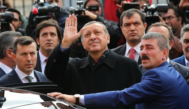 Turkey's President Recep Tayyip Erdoğan (C) escorted by his bodyguards waves to his supporters after he casts his vote outside a polling station, in Istanbul, on November 1, 2015. (AP Photo/Hussein Malla)