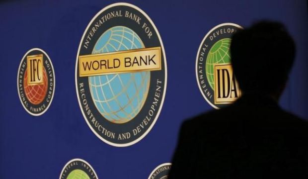 A man is silhouetted against the logo of the World Bank at the main venue for the International Monetary Fund (IMF) and World Bank annual meeting in Tokyo, Japan, on October 10, 2012. (Reuters/Kim Kyung-hoon)