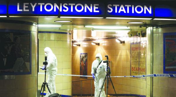 Two investigators gather evidence at Leytonstone station after the attack (Reuters)