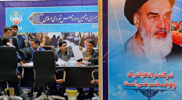 Iranian officials of interior ministry sit next to a picture of late Iranian supreme leader Ayatollah Ruhollah Khomeini (EPA)