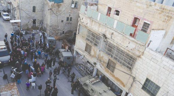 Jewish settlers demonstrating yesterday in front of a house in Hebron that they evacuated from last week (EPA) 