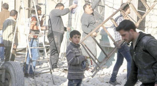 Residents of the Hay Al-Firdaws neighbourhood in Aleppo try to repair what was destroyed in a Syrian regime air strike yesterday (Reuters)