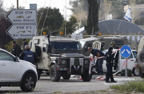 Israeli security forces inspect the scene where a Palestinian, who the Israeli military said tried to stab soldiers, was shot dead at Gush Etzion junction, south of the West Bank city of Bethlehem March 18, 2016. REUTERS/Mussa Qawasma