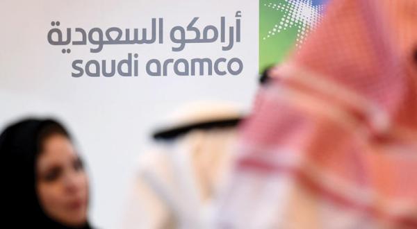 Participants standing in front of Aramco’s logo on the sidelines of the Global Competitiveness Forum in Riyadh on the 25th of January, 2016 (AFP)