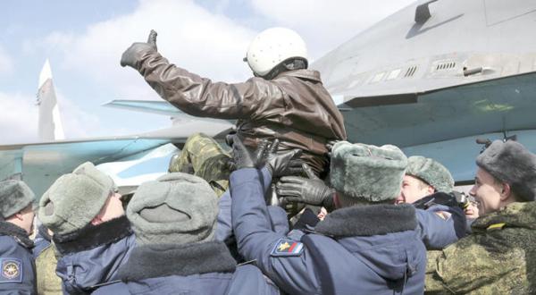 Members of the Russian air forces express their joy after returning to their country yesterday (AP)