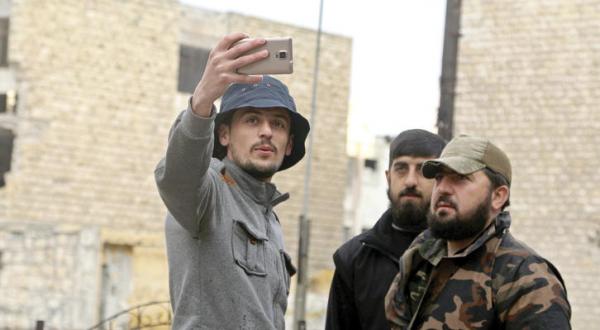 Syrian young man taking a “selfie” with armed Syrian Opposition armed forces in Aleppo, Syria - Reuters