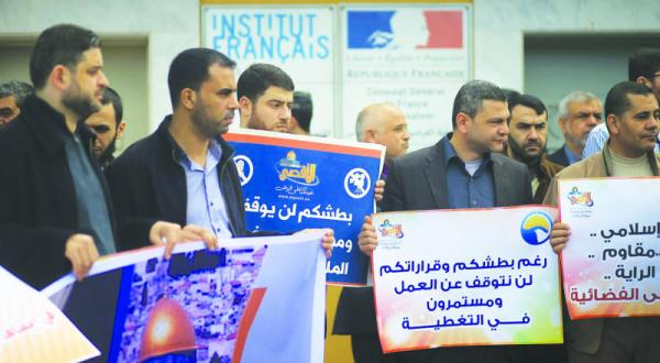 Employees of the TV channel “Al-Aqsa” demonstrate in front of the French embassy building in Gaza in protest at the channel closing down (AFP)